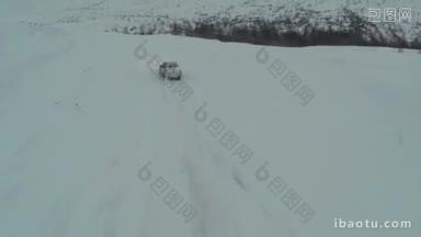 航拍在冬天下雪的路上开车在乡村的后视图